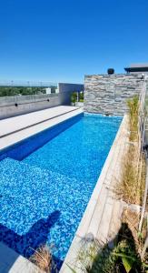 a swimming pool with blue water in front of a building at Tigre a estrenar in Tigre