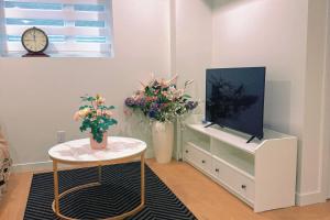 a living room with flowers and a tv and a table at Kris Anclam in Langley