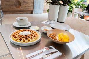 a table with a waffle and a bowl of fruit at BoH Collection in Medellín
