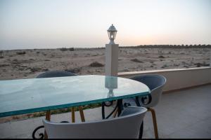 a table and chairs with a light on the beach at Le mirage in Tozeur