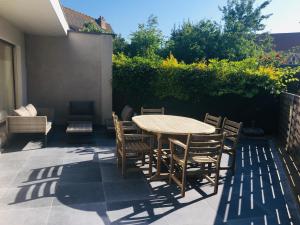a wooden table and chairs on a patio at Villa Tamarisk - + box in Middelkerke