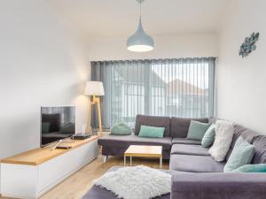 a living room with a couch and a tv at Villa Tamarisk - + box in Middelkerke