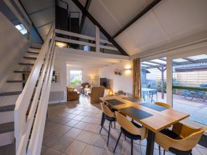 a dining room and living room with a table and chairs at Westenwind - Nr. 3 + park. in Middelkerke