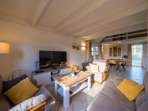 a living room with couches and a tv and a table at Westenwind - Nr. 3 + park. in Middelkerke
