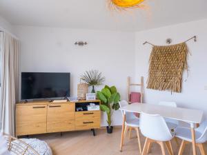 a living room with a tv and a table and chairs at Nautilus - 0301 in Westende-Bad +4 photos