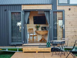 a tiny house with a patio and a table at Vilasini Hut by Tiny Away in Great Horkesley