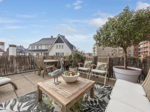 a balcony with a bird statue on a wooden table at Rising Sun - 0101 in Westende-Bad