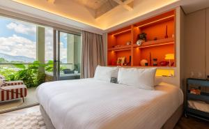 a bedroom with a large bed and a large window at BoH Collection in Medellín