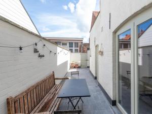 a patio with a bench and a table on a building at Notre Dame in Nieuwpoort