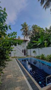 a swimming pool in front of a house at Ocean Crest Apartments in Mihiripenne