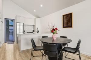 a kitchen and dining room with a table and chairs at Roam Taupo Lakefront Combined Units 1&2 in Taupo +44 photos