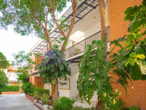 a brick building with a balcony and plants at Prukpibul Apartment in Bangkok