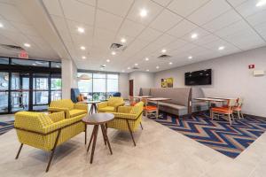 a waiting room with yellow chairs and tables at Hampton Inn Winchester in Winchester
