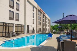a hotel with a swimming pool and an umbrella at Hampton Inn Winchester in Winchester