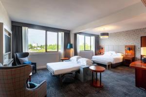 a hotel room with two beds and a chair at Hilton Strasbourg in Strasbourg