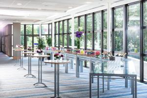 a rendering of a lobby with tables and windows at Hilton Strasbourg in Strasbourg