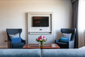 a living room with two chairs and a tv at Hilton Strasbourg in Strasbourg +50 photos