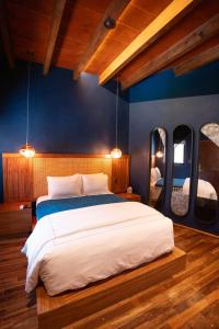 a bedroom with a large bed with blue walls at Hotel Bitos Boutique in San Miguel de Allende