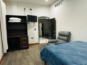 a bedroom with a bed and a chair and a mirror at Borde del lago in Panajachel
