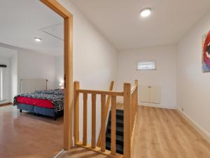 a bedroom with a bed and a staircase in a room at Landhuis Brakelbos in Brakel