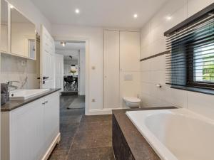 a bathroom with a tub and a sink and a toilet at Landhuis Brakelbos in Brakel