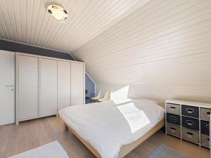 a bedroom with a white bed and a wooden ceiling at Maison Odille in Sint-Laureins +36 photos