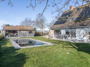 a house with a swimming pool in the yard at Maison Odille in Sint-Laureins