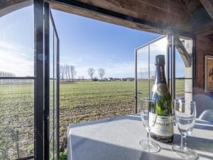 a bottle of wine sitting on a table with glasses at Maison Odille in Sint-Laureins