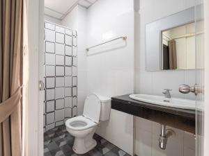 a white bathroom with a toilet and a sink at Prukpibul Apartment in Bangkok +41 photos