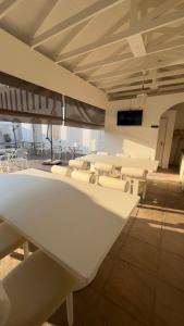 a room with white chairs and tables in a building at 18 On OniX Lodge & Spa - World Class in Four Ways