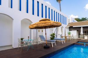 a patio with chairs and an umbrella next to a swimming pool at 18 On OniX Lodge & Spa - World Class in Four Ways