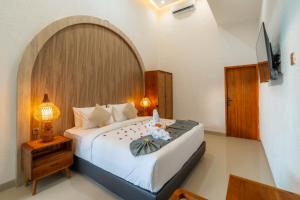 a bedroom with a large bed and a lamp at Ghania Villas Melasti in Ungasan +92 photos