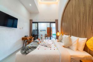 a bedroom with a bed with two stuffed animals on it at Ghania Villas Melasti in Ungasan