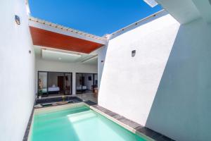 a swimming pool in the courtyard of a house at Ghania Villas Melasti in Ungasan