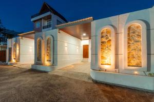 a white building with windows and lights on it at Ghania Villas Melasti in Ungasan