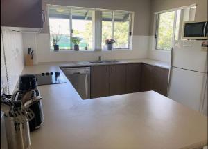 a kitchen with a white refrigerator and a sink at Modern Beach Apartment in Gladstone
