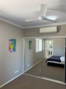 a bedroom with a mirror and a bed and a ceiling at Modern Beach Apartment in Gladstone