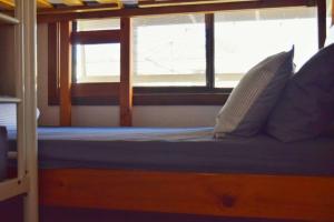 a bed with pillows and a window on a boat at Yarrawonga Holiday House with Open Fireplace in Yarrawonga