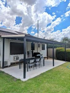a patio with a table and chairs on it at Yarrawonga Holiday House with Open Fireplace in Yarrawonga