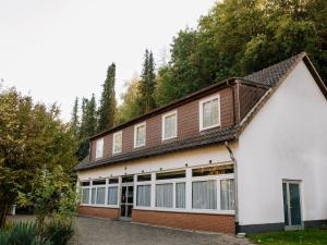 a white and brown building with trees in the background at Friedensthal in Bad Pyrmont