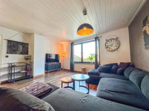 a living room with a couch and a clock on the wall at Burgen in Burgen