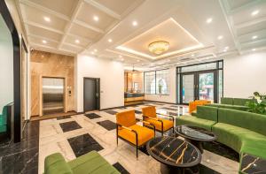 a lobby with a green couch and orange chairs at Dream Future VangVieng Hotel in Vang Vieng