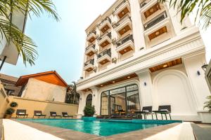 a hotel with a swimming pool in front of a building at Dream Future VangVieng Hotel in Vang Vieng