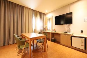 a hotel room with a table and a television at Ingye Joy Hotel in Suwon