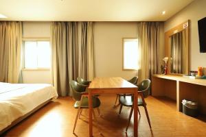 a hotel room with a bed and a table and chairs at Ingye Joy Hotel in Suwon