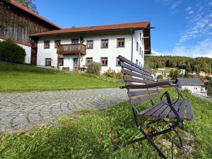 a park bench sitting in front of a building at Weitblick in Zenting