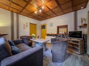 a living room with couches and a table and a television at Knusperhäuschen in Engenstein