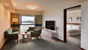 a hotel room with a bed and a table and chairs at Ormond Sandakan in Sandakan