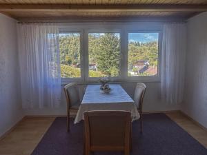a dining room with a table and two windows at Talblick in Schönbrunn +10 photos