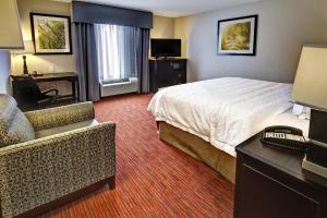a hotel room with a bed and a desk and a chair at Hampton Inn and Suites Ada in Ada